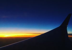 Flygplansvinge i solnedgång