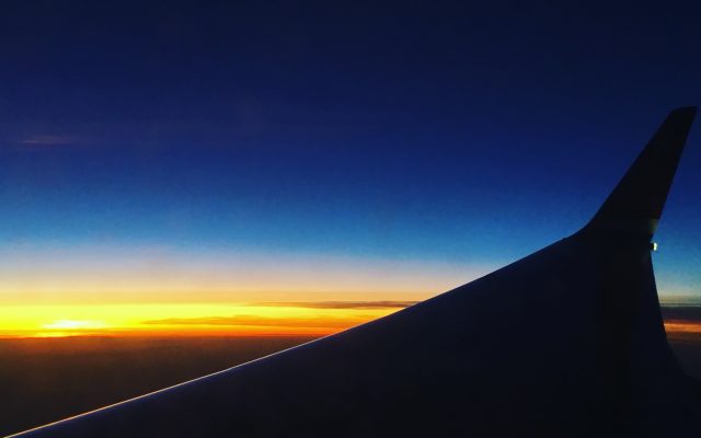 Flygplansvinge i solnedgång